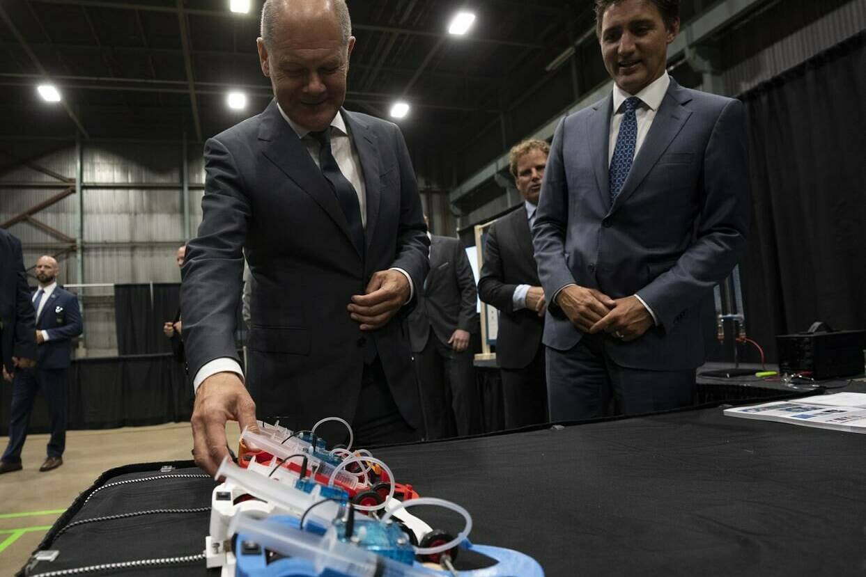 Canadian Prime Minister Justin Trudeau looks on as German Chancellor Olaf Scholz examines a hydrogen powered model car as they tour a trade show, Tuesday, August 23, 2022 in Stephenville, Newfoundland and Labrador. THE CANADIAN PRESS/Adrian Wyld