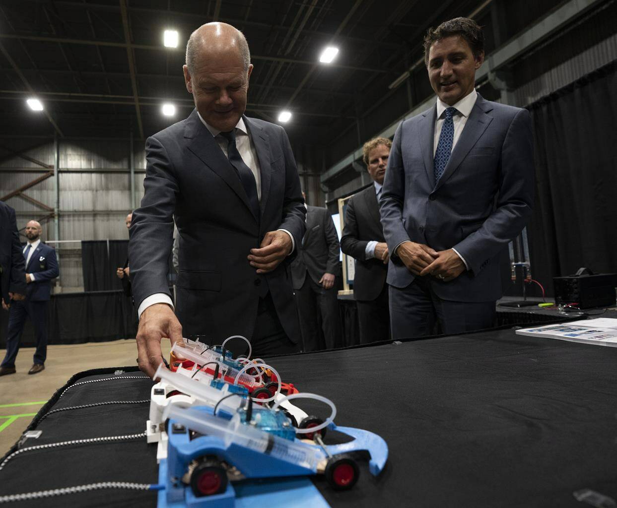 Canadian Prime Minister Justin Trudeau looks on as German Chancellor Olaf Scholz examines a hydrogen powered model car as they tour a trade show, Tuesday, August 23, 2022 in Stephenville, Newfoundland and Labrador. THE CANADIAN PRESS/Adrian Wyld