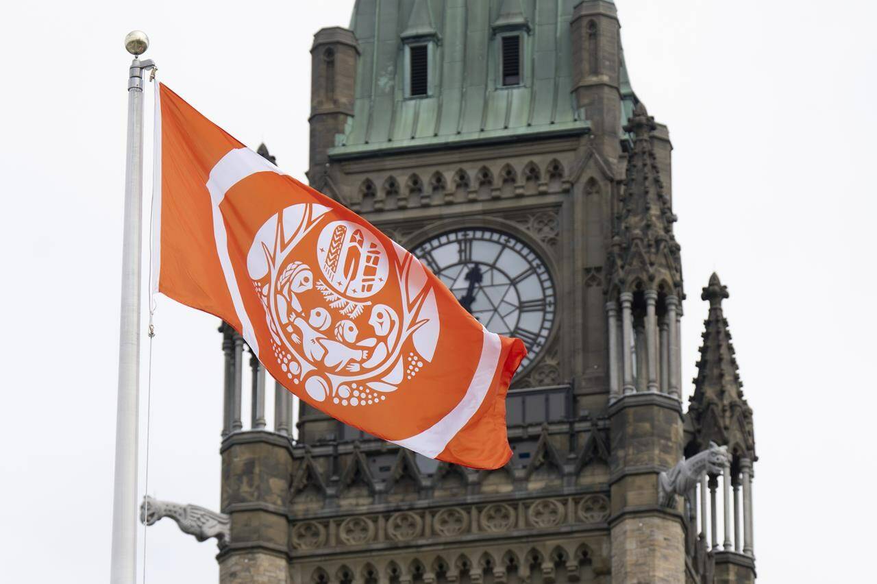 The Survivor’s flag flies on Parliament Hill beside the Peace tower, Monday, August 29, 2022 in Ottawa. THE CANADIAN PRESS/Adrian Wyld