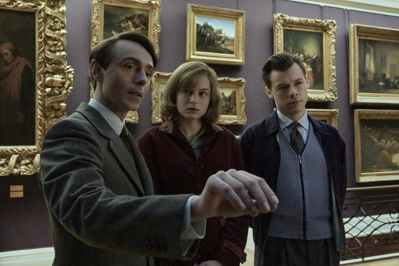 This image released by Amazon shows, from left, David Dawson, Emma Corrin and Harry Styles in a scene from “My Policeman.” (Parisa Taghizadeh/Amazon via AP)