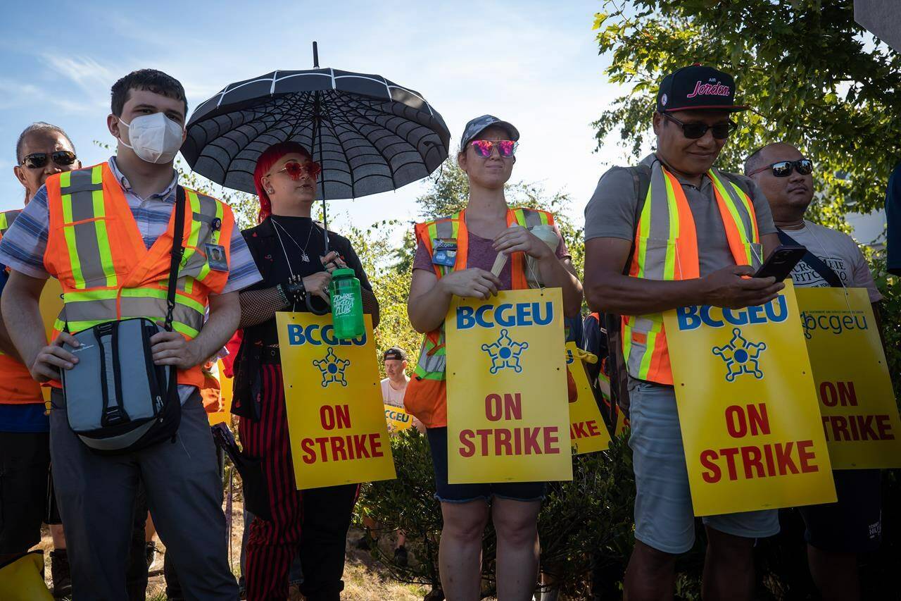 Members of the British Columbia General Employees’ Union picket outside a B.C. Liquor Distribution Branch facility, in Delta, B.C., on August 15, 2022. British Columbia’s largest public-sector union says it is standing down after more than two weeks of limited job action, following the resumption of contract talks.THE CANADIAN PRESS/Darryl Dyck