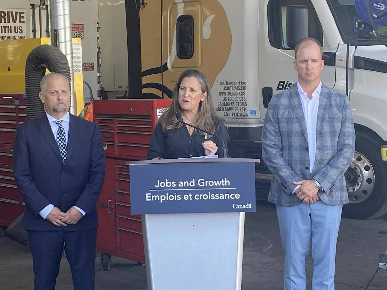 Finance Minister and Deputy Prime Minster Chrystia Freeland speaks in Calgary, Wednesday, Aug. 31, 2022, flanked by Steven Laskowski (left), president of Canadian Trucking Alliance and Trevor Fridfinnson (right), chief operating officer at Bison Transport. THE CANADIAN PRESS/Bill Graveland