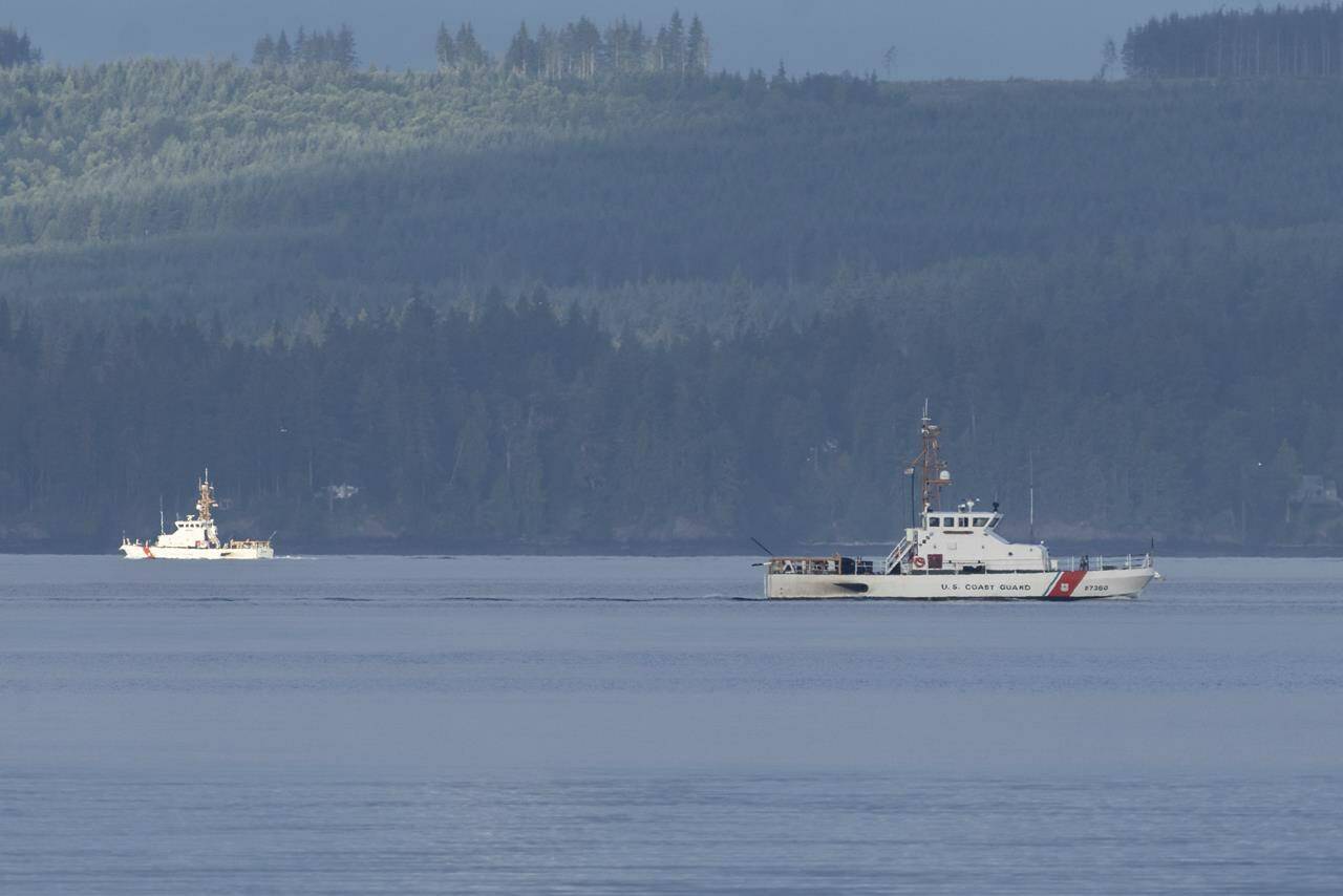 A pair of U.S. Coast Guard vessels searches the area, Monday, Sept. 5, 2022, near Freeland, Wash., on Whidbey Island north of Seattle where a chartered float plane crashed the day before. The plane was carrying 10 people and was en route from Friday Harbor, Wash., to Renton, Wash. (AP Photo/Stephen Brashear)