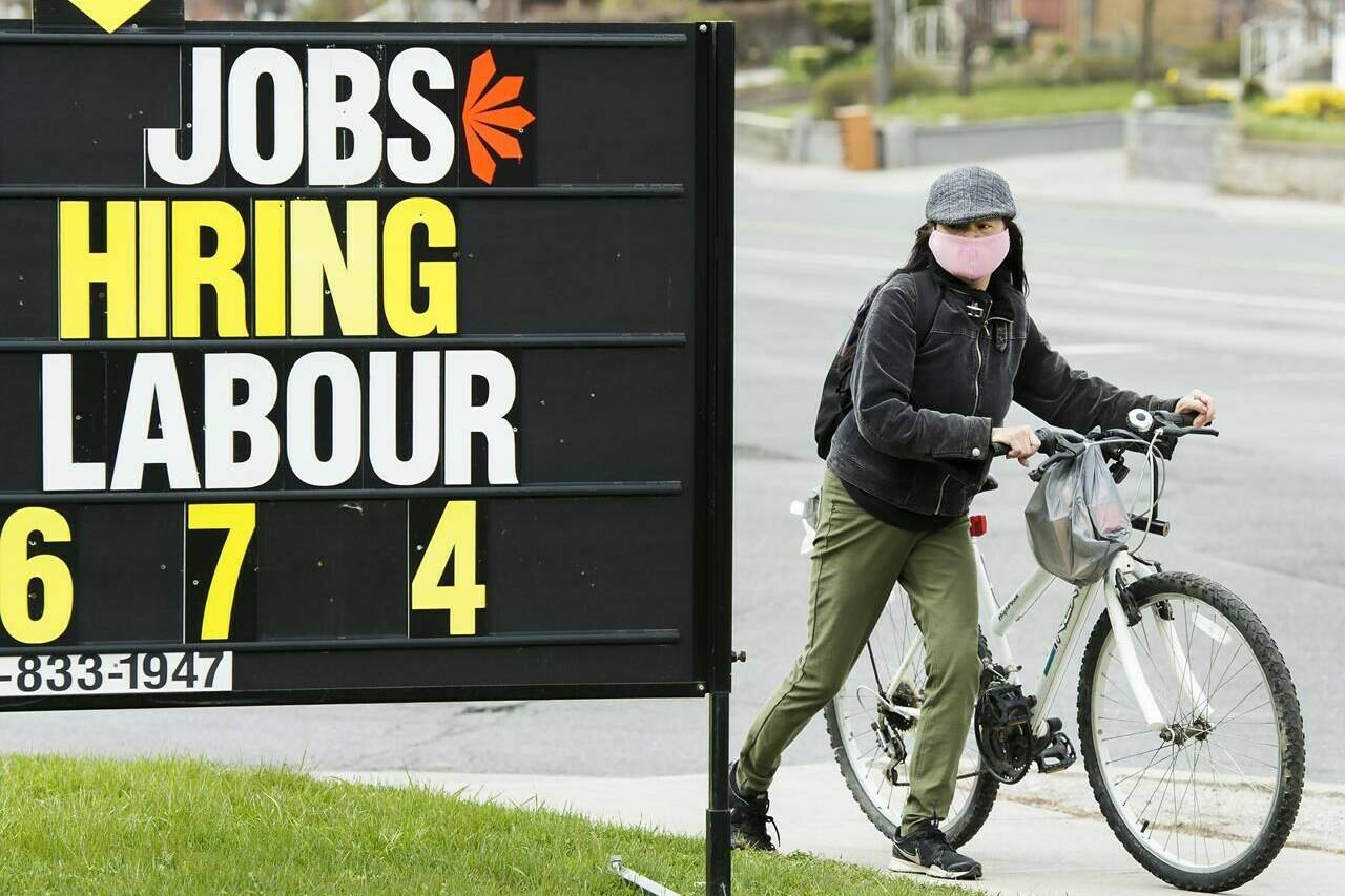 A woman checks out a jobs advertisement sign during the COVID-19 pandemic in Toronto on Wednesday, April 29, 2020. Statistics Canada will release its latest reading on the job market on Friday. The agency will release its labour force survey for April. THE CANADIAN PRESS/Nathan Denette