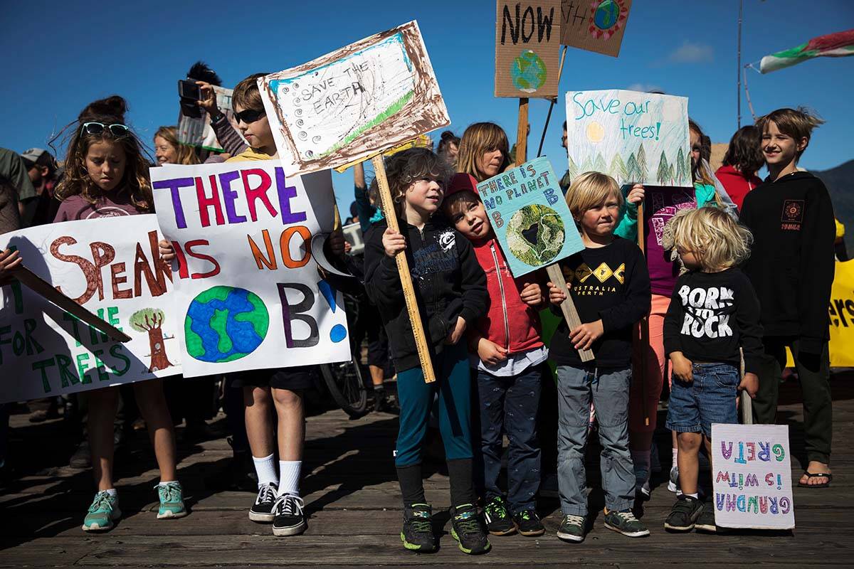 Kids gather on one of the main docks in Tofino, as they participate in a massive global climate strike, in Tofino, B.C. on Sept. 27, 2019. In a national report released in 2022, study authors found climate change to be one of the top 10 threats facing children and youth in Canada. (THE CANADIAN PRESS/Melissa Renwick)