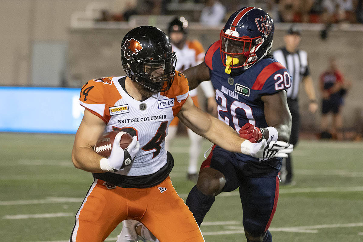 B.C. Lions fullback David Mackie (34) protects the ball from Montreal Alouettes running back Jeshrun Antwi (20) during first half CFL football action in Montreal on Friday, September 9, 2022. THE CANADIAN PRESS/Peter McCabe