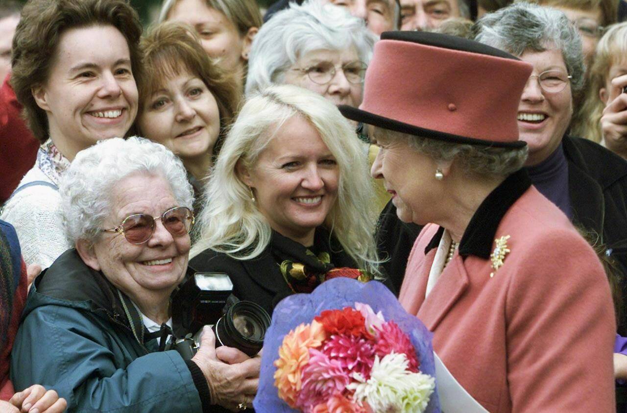 Queen Elizabeth II brings smiles to the faces of well wishers during an impromptu walkabout after attending a church service in Victoria, B.C. on Sunday Oct. 6, 2002. THE CANADIAN PRESS/Adrian Wyld