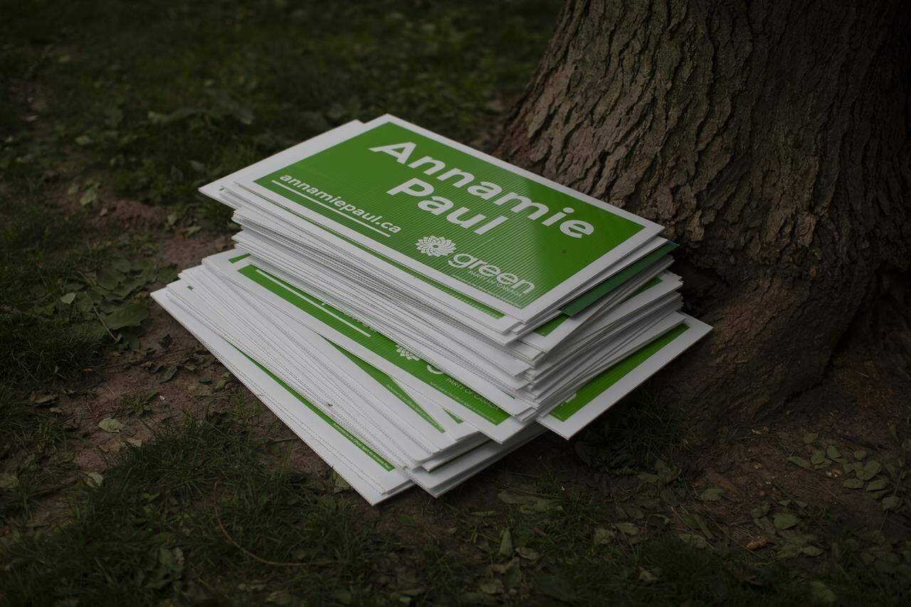Sign boards for Annamie Paul, then-leader of the federal Green Party, are piled by a tree ahead of a news briefing in Toronto, Monday, July 19, 2021. THE CANADIAN PRESS/Chris Young