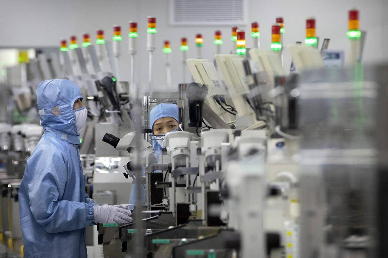 Employees wearing protective equipment work at a semiconductor production facility during a government organized tour for journalists in Beijing, on May 14, 2020. Canada’s technology industry says flaring tensions between China and Taiwan are reminding companies how important it is to seek a broader range of sources for semiconductors, and to invest in the sector. THE CANADIAN PRESS/AP, Mark Schiefelbein