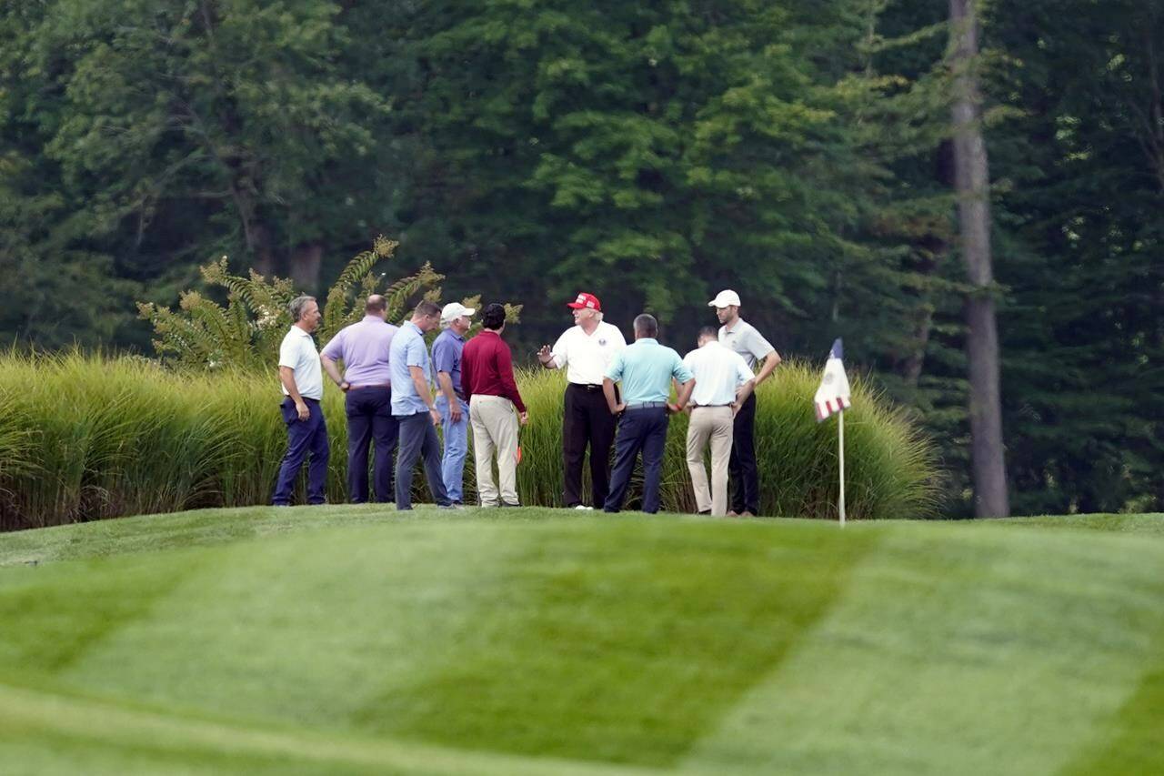 Former President Donald Trump, center, stands on his golf course with others at Trump National Golf Club in Sterling, Va., Monday, Sept. 12, 2022. (AP Photo/Alex Brandon)