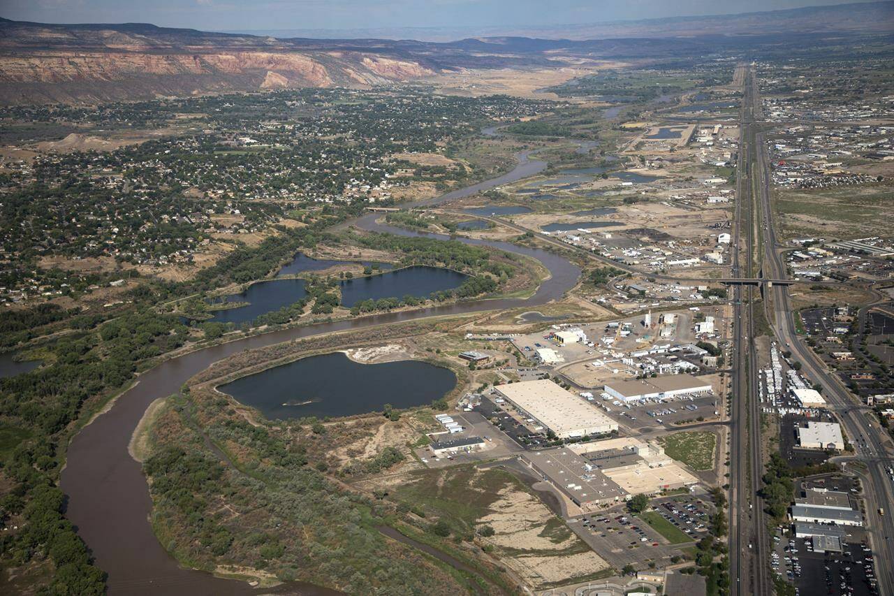 The Colorado River passes through Grand Junction, Aug. 24, 2022, in Mesa County, Colo. In November 1922, seven land-owning white men brokered a deal to allocate water from the Colorado River, which winds through the West and ends in Mexico. During the past two decades, pressure has intensified on the river as the driest 22-year stretch in the past 1,200 years has gripped the southwestern U.S. (Hugh Carey/The Colorado Sun via AP)