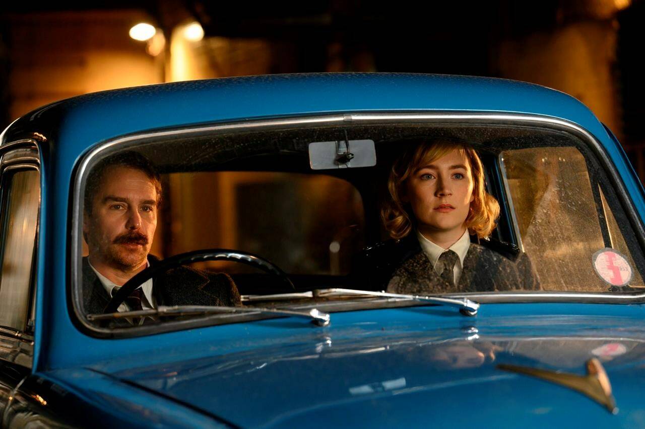 This image released by Searchlight Pictures shows Sam Rockwell and Saoirse Ronan in a scene from “See How They Run.” (Parisa Taghizadeh/Searchlight Pictures via AP)