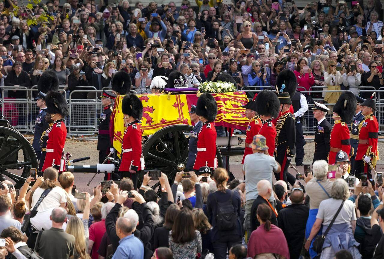 Thousands of people line the streets as the coffin of Queen Elizabeth leaves Buckingham Palace, followed by King Charles lll and Royal Family members as they make their way to Westminster Hall where the Queen will lie in state, in London on Wednesday, September 14, 2022. THE CANADIAN PRESS/Nathan Denette