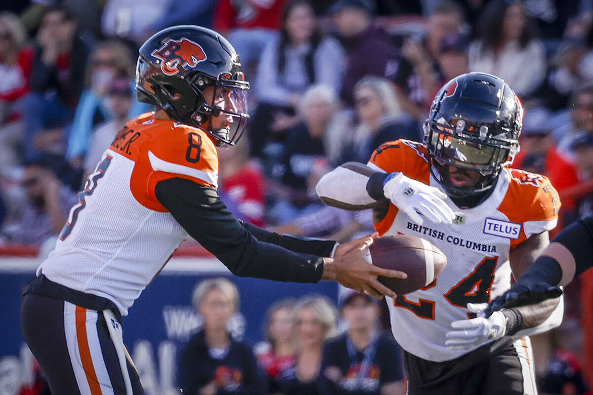 BC Lions quarterback Vernon Adams, left, hands the ball off to running back James Butler during first half CFL football action against the Calgary Stampeders in Calgary, Saturday, Sept. 17, 2022.THE CANADIAN PRESS/Jeff McIntosh