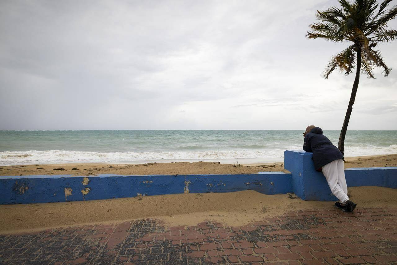 A man stands near a beach before the arrival of Tropical Storm Fiona in San Juan, Puerto Rico, Saturday, Sept. 17, 2022. Fiona was expected to become a hurricane as it neared Puerto Rico on Saturday, threatening to dump up to 20 inches (51 centimeters) of rain as people braced for potential landslides, severe flooding and power outages. (AP Photo/Alejandro Granadillo)