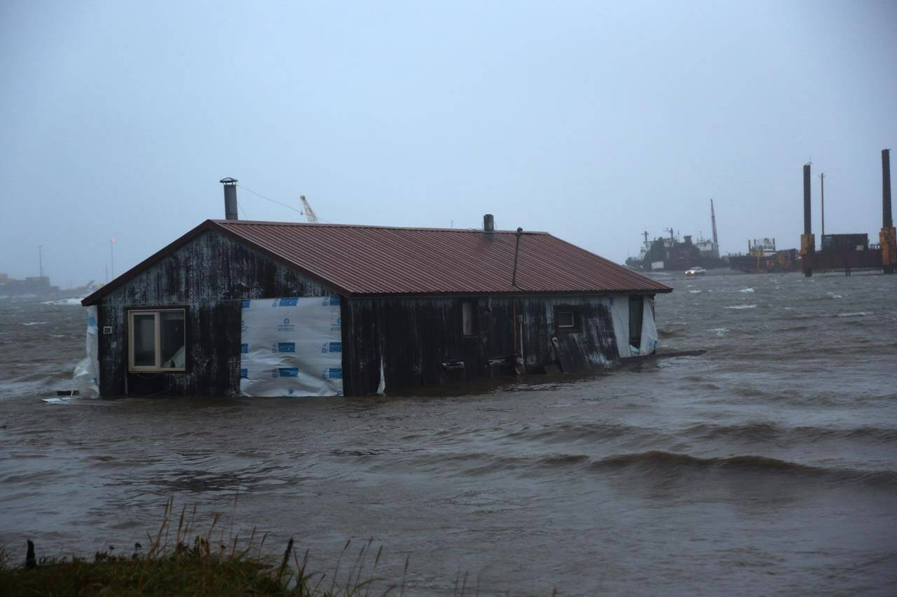 A home is seen floating in the Snake River near Nome, Alaska, on Saturday, Sept. 17, 2022. Much of Alaska’s western coast could see flooding and high winds as the remnants of Typhoon Merbok moved into the Bering Sea region. The National Weather Service says some locations could experience the worst coastal flooding in 50 years. (AP Photo/Peggy Fagerstrom)