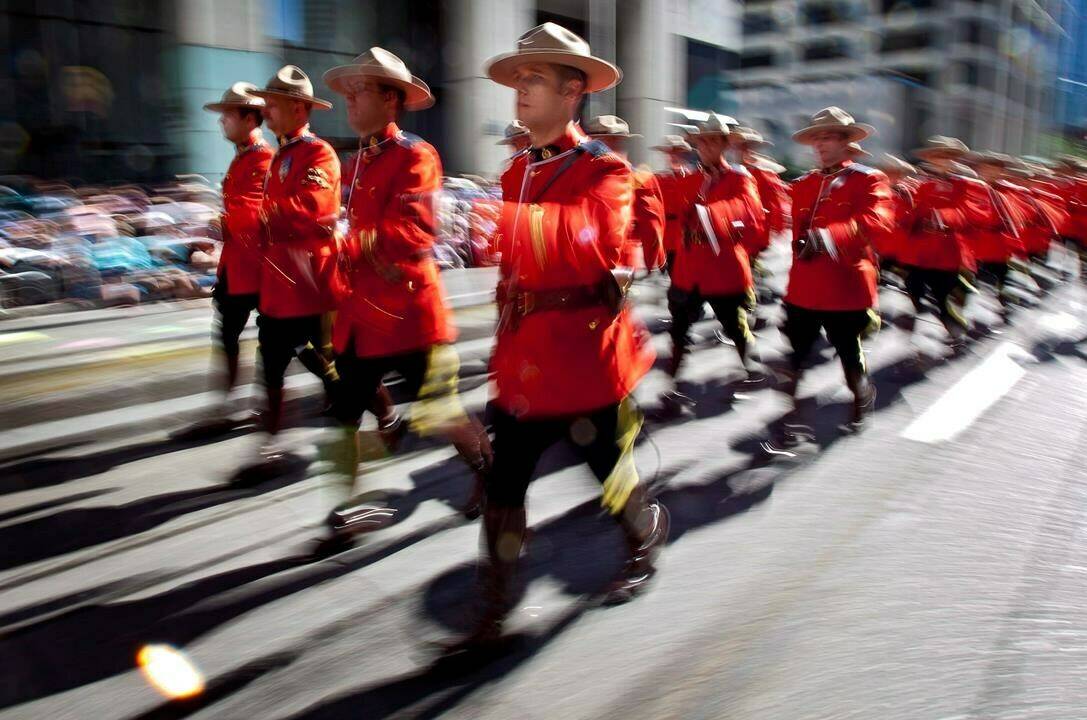 Members of the Royal Canadian Mounted Police march during the Calgary Stampede parade in Calgary, Friday, July 6, 2012. Members of the military and RCMP will parade through the streets of Ottawa at 12:10 p.m., in tribute to Queen Elizabeth, and sound a 96-gun salute -- one salvo for every year of the queen's life. THE CANADIAN PRESS/Jeff McIntosh