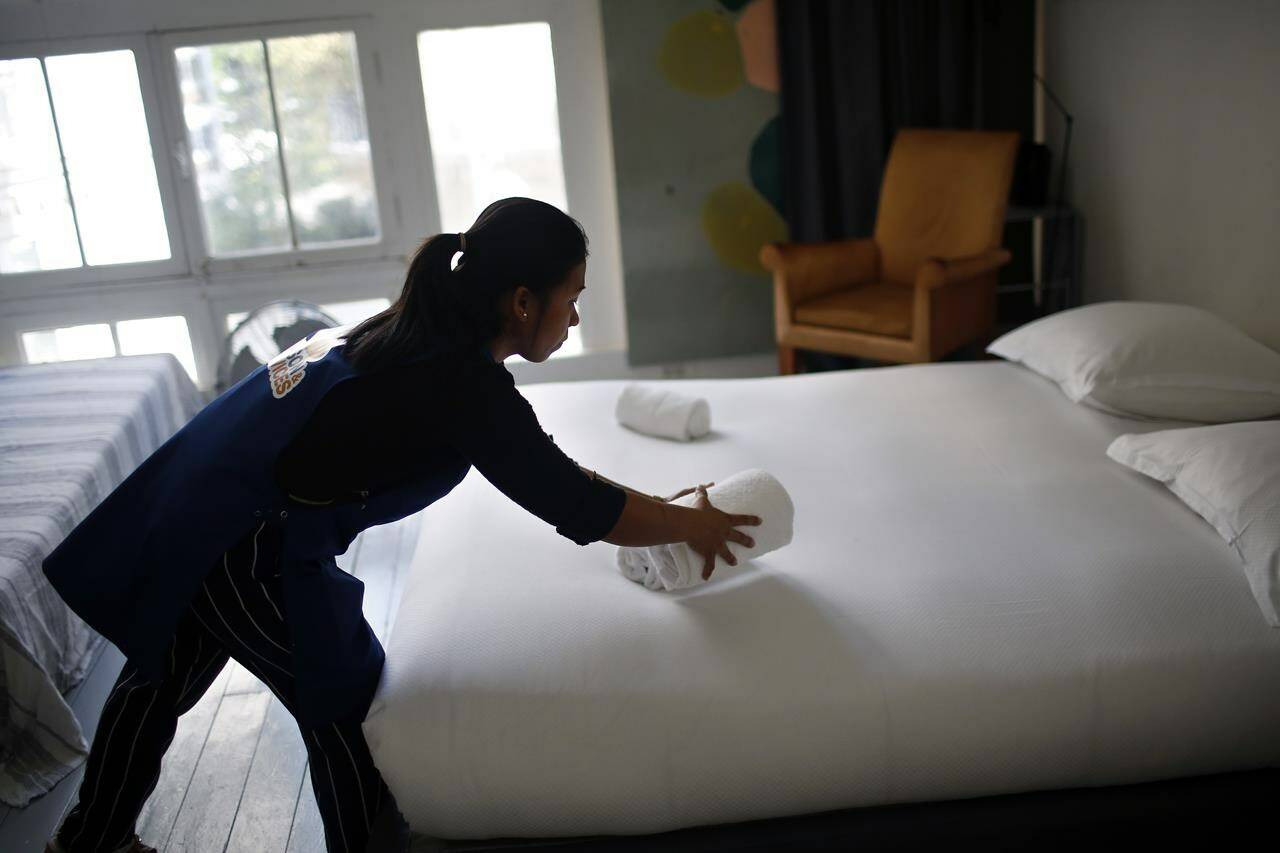FILE - In this Thursday, Sept. 20, 2018 photo, a cleaning lady works in an apartment located on Airbnb in Paris. Airbnb hosts are facing an onslaught of frustrations born of renting out their properties to short-term guests. Certain guests have proven disrespectful of hosts’ homes, with some squatting illegally — and getting away with it — and others trashing properties with Silly String, feces and more. (AP Photo/Thibault Camus, file)