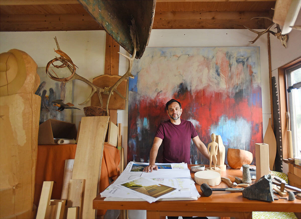 Indigenous artist John Marston in his Chemainus studio.The painting behind him is by his friend, Ladysmith artist Dennis Brown. In front of him are architectural plans for new artist studios in Ladysmith that he is helping to design. Don Denton photo.