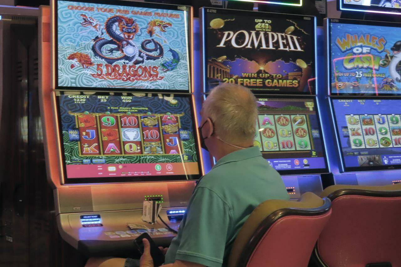 A man plays a slot machine at the Hard Rock Casino in Atlantic City N.J. on Aug. 8, 2022. On Sept. 16, 2022, New Jersey gambling regulators reported that the state’s casinos, horse tracks that offer sports betting and the online partners of both types of gambling outlets won $470.6 million from gamblers in August, up nearly 10% from a year earlier. (AP Photo/Wayne Parry)