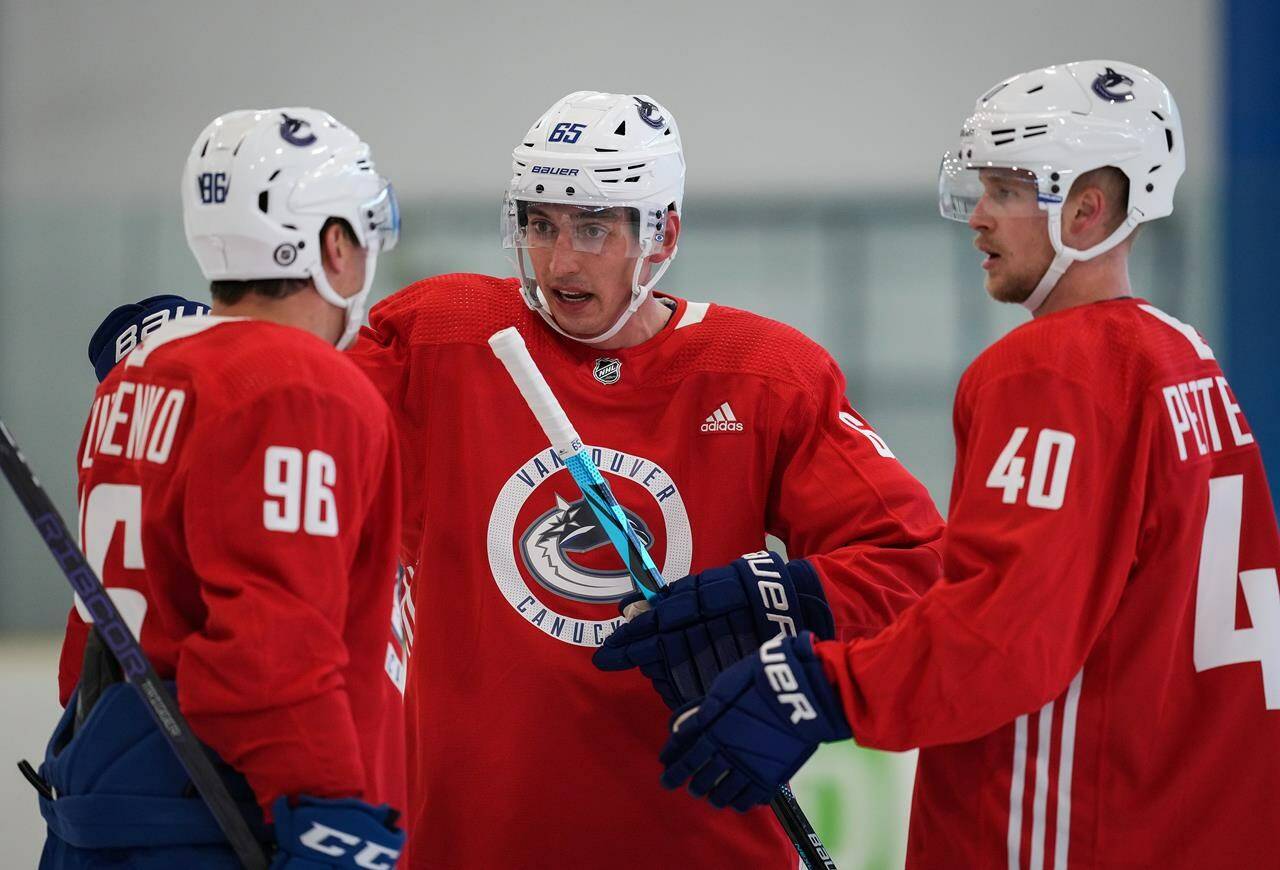 Vancouver Canucks’ Ilya Mikheyev, centre, of Russia, talks to Andrei Kuzmenko, left, of Russia, and Elias Pettersson, of Sweden, during the NHL hockey team’s training camp in Whistler, B.C., Thursday, Sept. 22, 2022. THE CANADIAN PRESS/Darryl Dyck