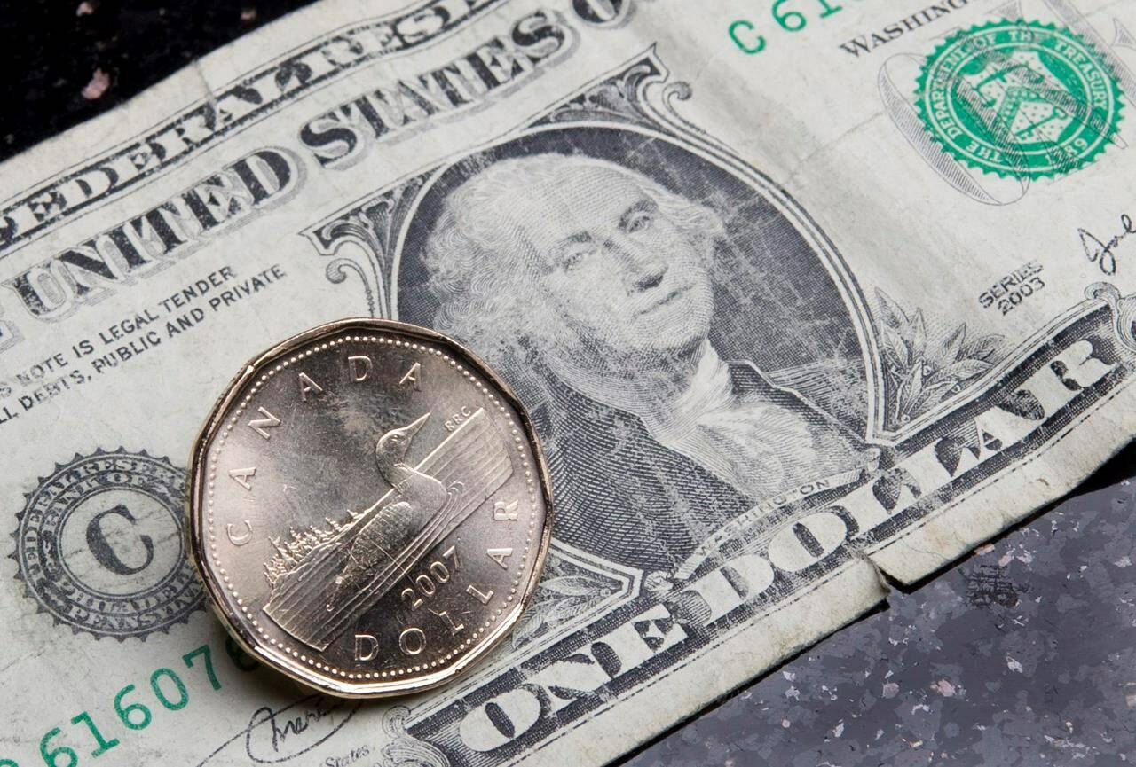 A Canadian dollar is placed by an American dollar in Ottawa, Thursday Sept. 20, 2007. High inflation and a strong U.S. dollar will weigh heavily on Canadian snowbirds this winter, experts say. THE CANADIAN PRESS/Jonathan Hayward