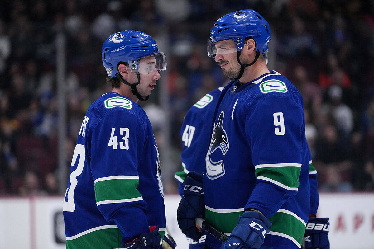 Vancouver Canucks’ Quinn Hughes, left, and J.T. Miller talk during a stoppage in play during the first period of a pre-season NHL hockey game against the Seattle Kraken in Vancouver, on Thursday, September 29, 2022. THE CANADIAN PRESS/Darryl Dyck