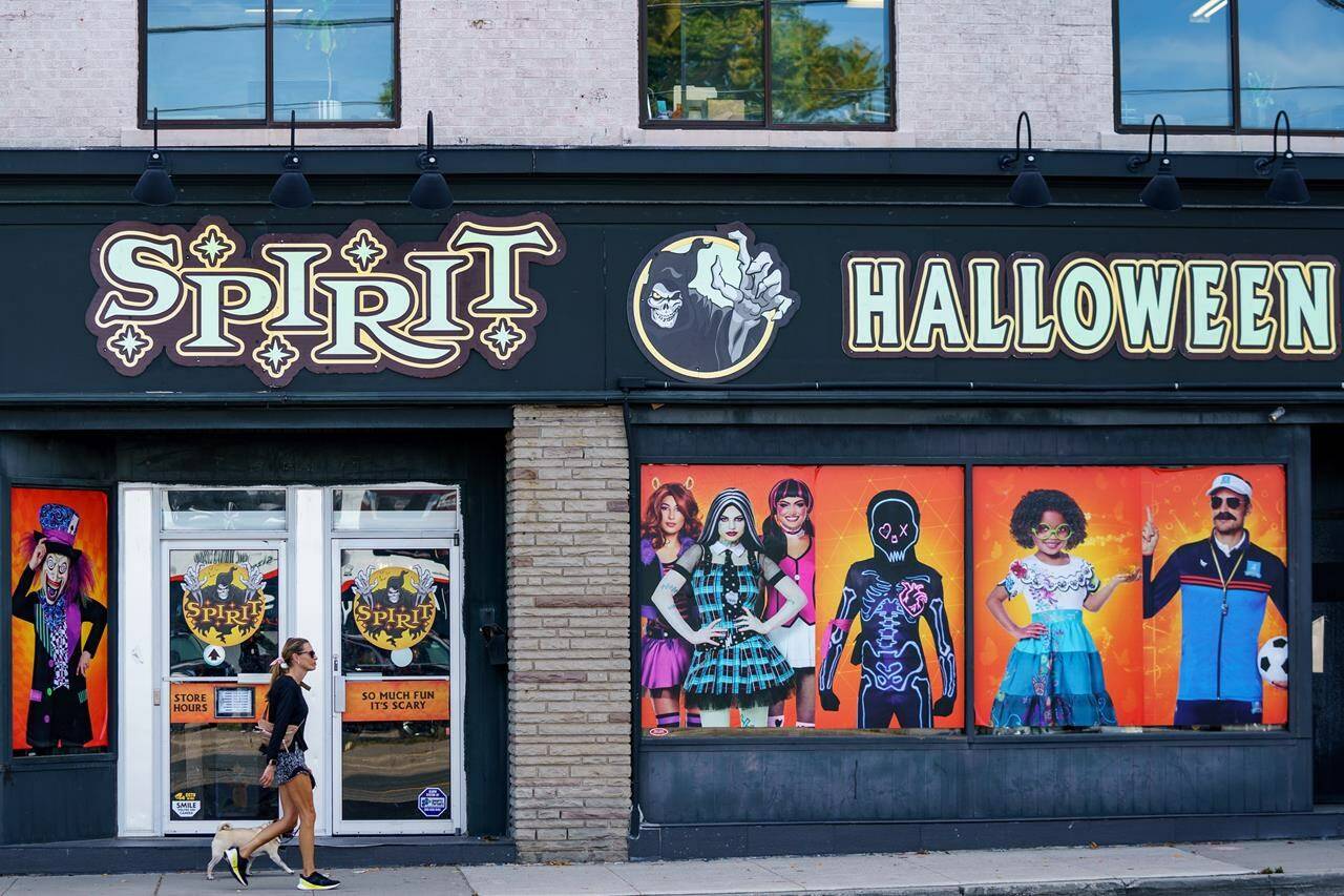 A person walks their dog past the storefront of a Spirit Halloween on Avenue Road, in Toronto, Wednesday, Sept. 21, 2022. After two years of COVID-19 restrictions curbing Halloween festivities, some Canadians may be willing to open their wallets wide for a trendy costume or candy for trick-or-treaters. THE CANADIAN PRESS/Alex Lupul