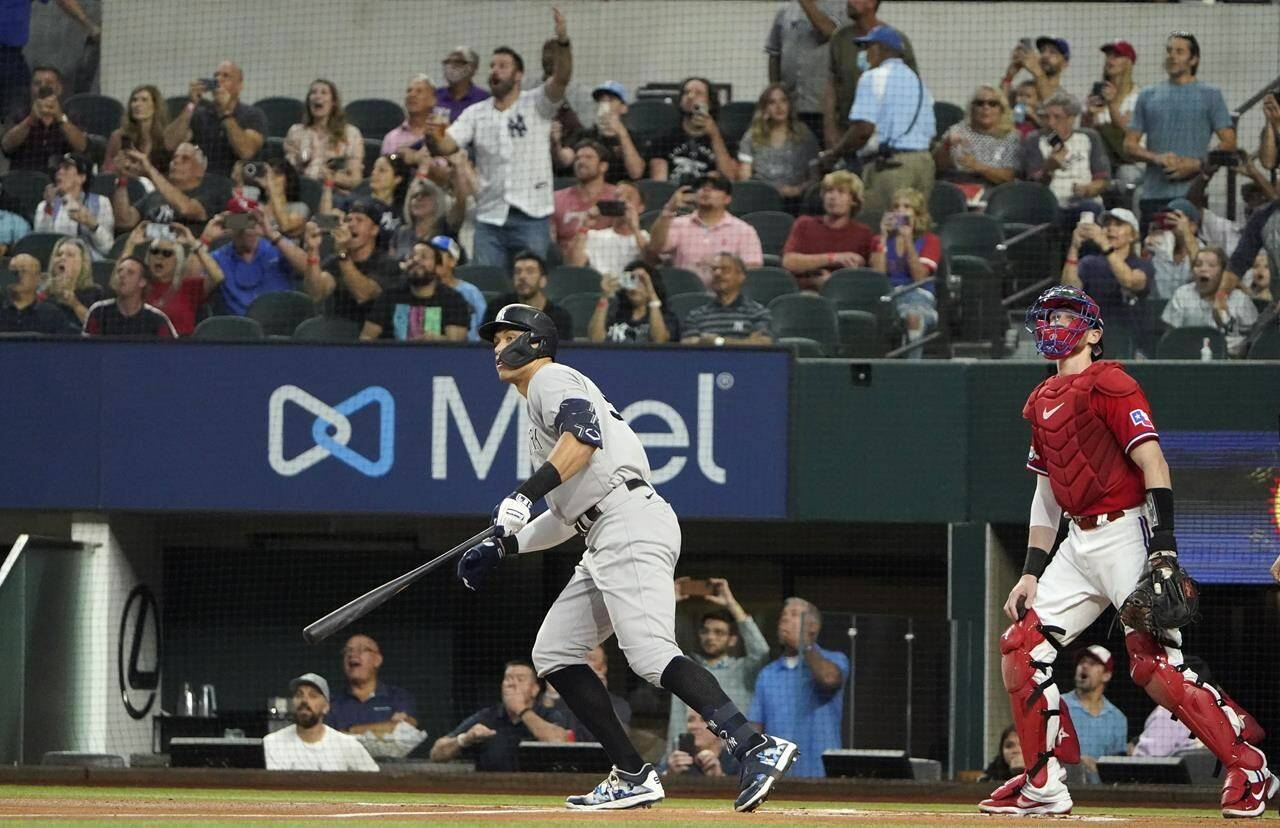 New York Yankees’ Aaron Judge, left, watches his solo home, his 62nd of the season, with Texas Rangers catcher Sam Huff during the first inning in the second baseball game of a doubleheader in Arlington, Texas, Tuesday, Oct. 4, 2022. With the home run, Judge set the AL record for home runs in a season, passing Roger Maris. (AP Photo/LM Otero)