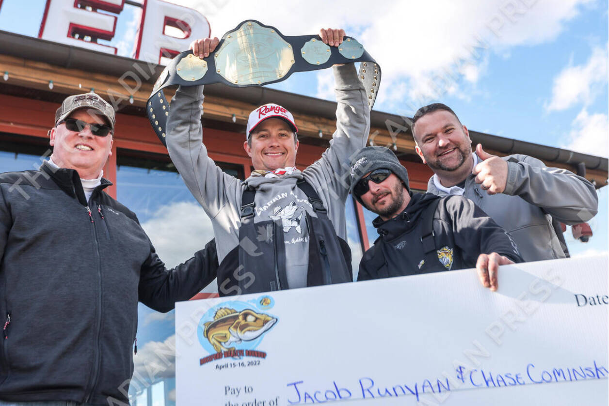 From left, Rossford, Ohio Mayor Neil MacKinnon III, Rossford Walleye Roundup Tournament champions Jacob Runyan, Chase Cominsky, and Bass Pro Shops general manager Tony Williamson celebrate on Saturday, April 16, 2022 at Bass Pro Shops in Rossford. Prosecutors in Cleveland are investigating an apparent cheating scandal during the lucrative walleye fishing tournament on Lake Erie. A Twitter video shows Jason Fischer, tournament director for the Lake Erie Walleye Trail event, on Friday cutting open walleye and finding lead weights and prepared fish filets inside the winning catch of five fish to bolster their weight. Anglers Runyan and Cominsky were disqualified. THE CANADIAN PRESS/The Blade via AP-Isaac Ritchey