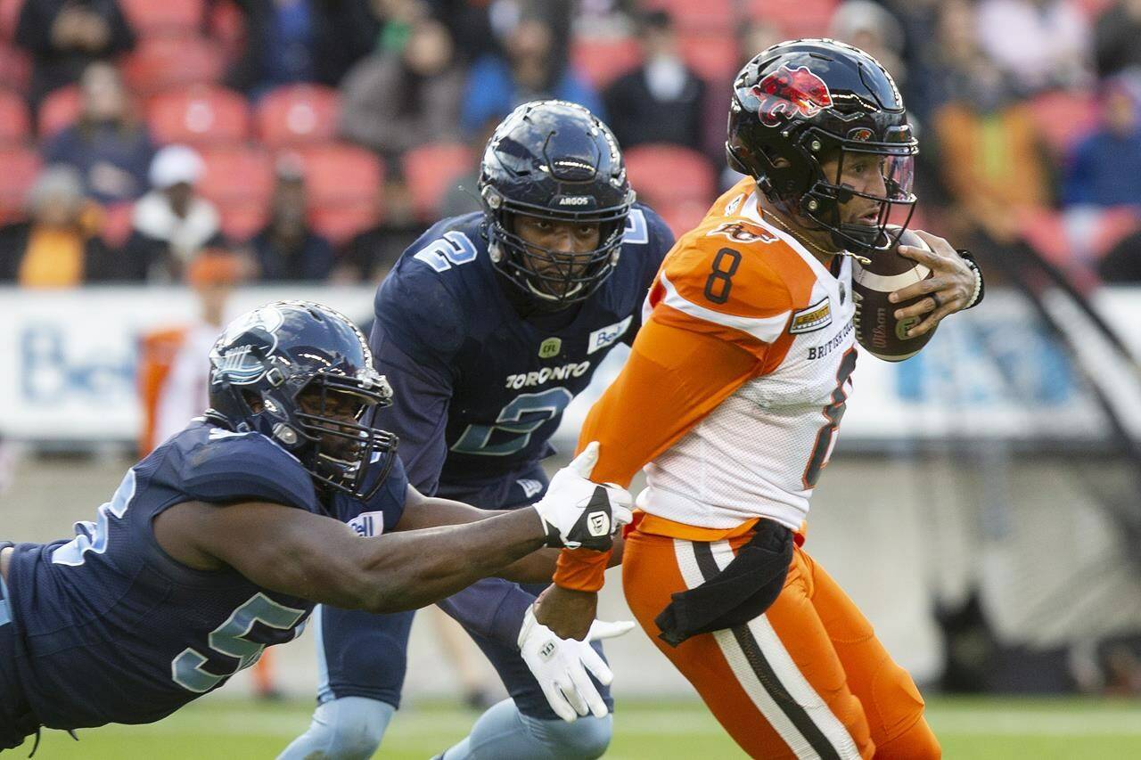 B.C. Lions quarterback Vernon Adams Jr. (right) evades Toronto Argonauts’ JaGared Davis during first half CFL football action in Toronto on Saturday October 8, 2022. THE CANADIAN PRESS/Chris Young