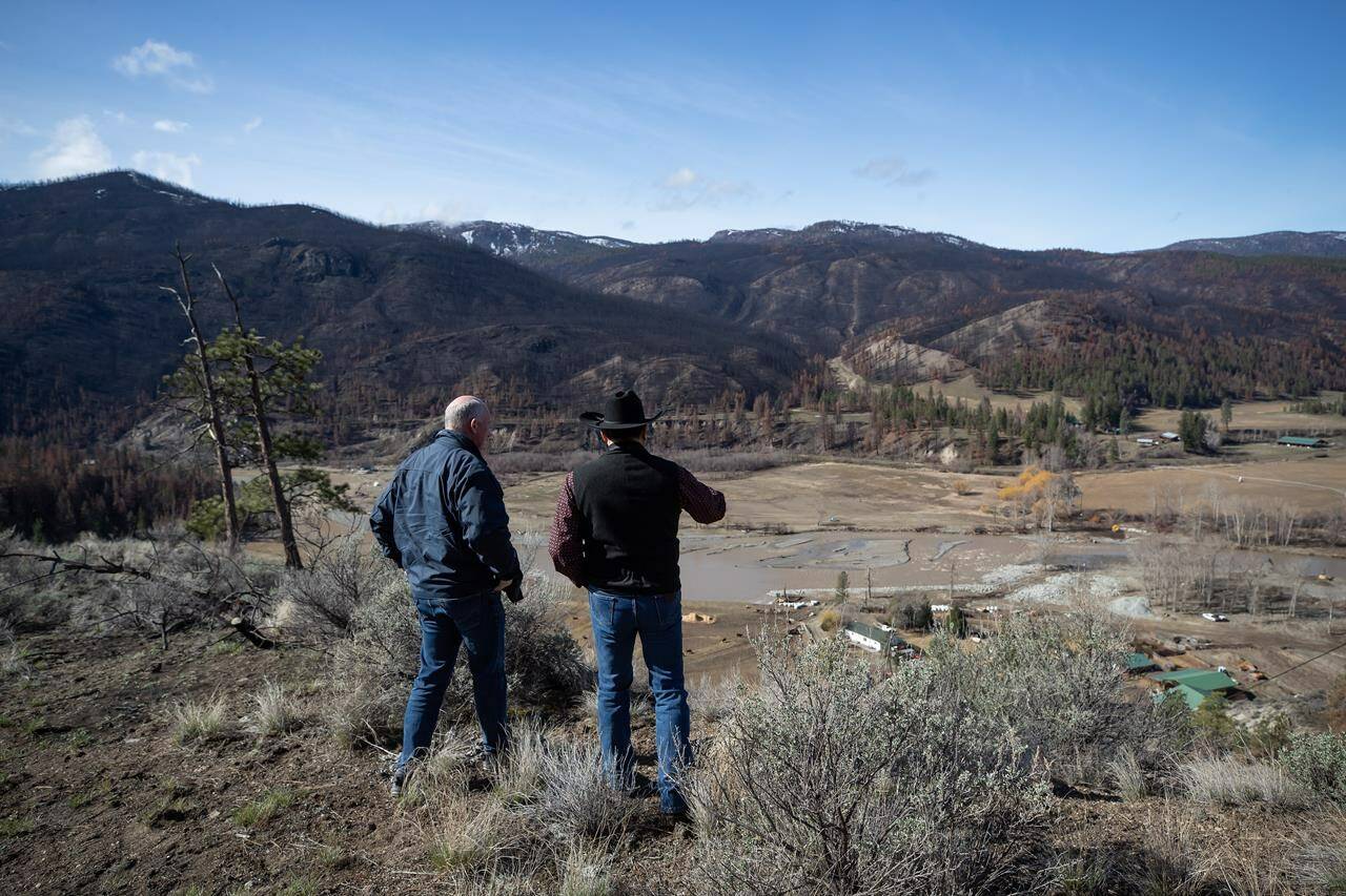 B.C. Minister of Public Safety Mike Farnworth, left, and Shackan Indian Band Chief Arnie Lampreau view damage to Shackan land caused by last summer’s wildfires and November flooding west of Merritt, B.C., on Thursday, March 24, 2022. THE CANADIAN PRESS/Darryl Dyck