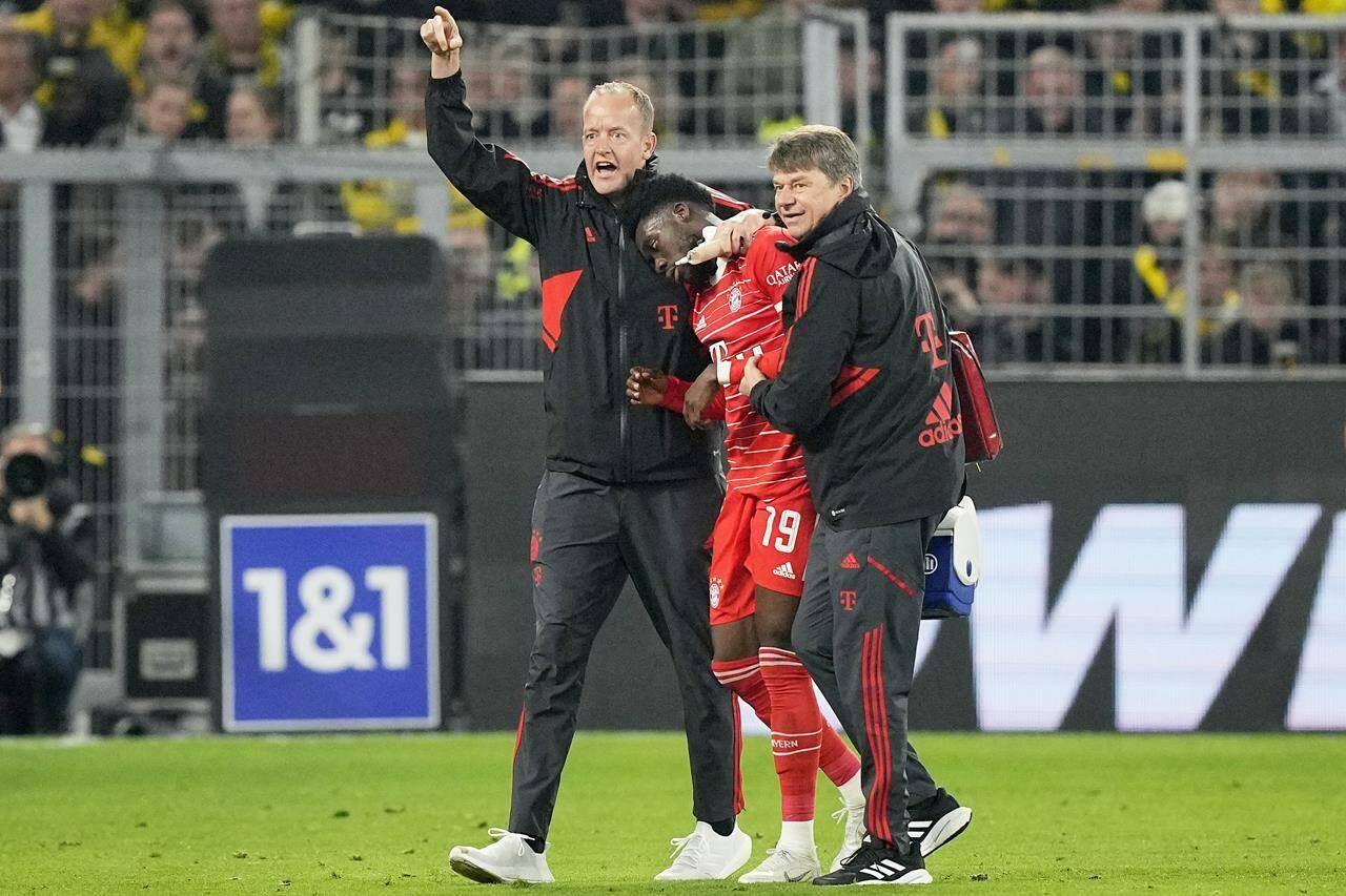 Bayern’s Alphonso Davies, center, leaves the field after getting injured during the German Bundesliga soccer match between Borussia Dortmund and Bayern Munich in Dortmund, Germany, Saturday, Oct. 8, 2022. THE CANADIAN PRESS/AP-Martin Meissner