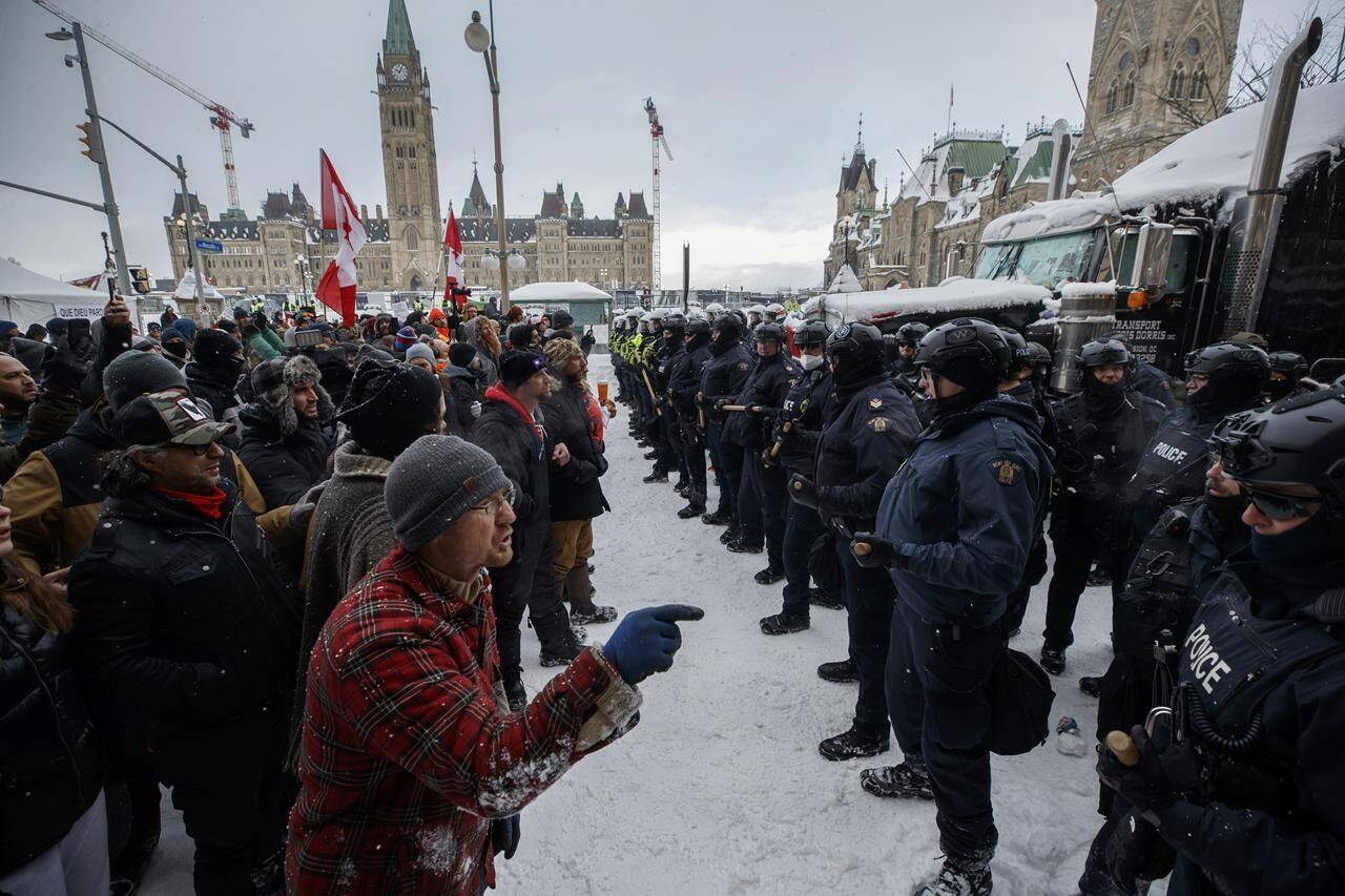 Police move in to clear downtown Ottawa near Parliament hill of protesters after weeks of demonstrations on Saturday, Feb. 19, 2022. The much-anticipated public inquiry into the federal government’s unprecedented use of the Emergencies Act during “Freedom Convoy” protests last winter begins Thursday. THE CANADIAN PRESS/Cole Burston