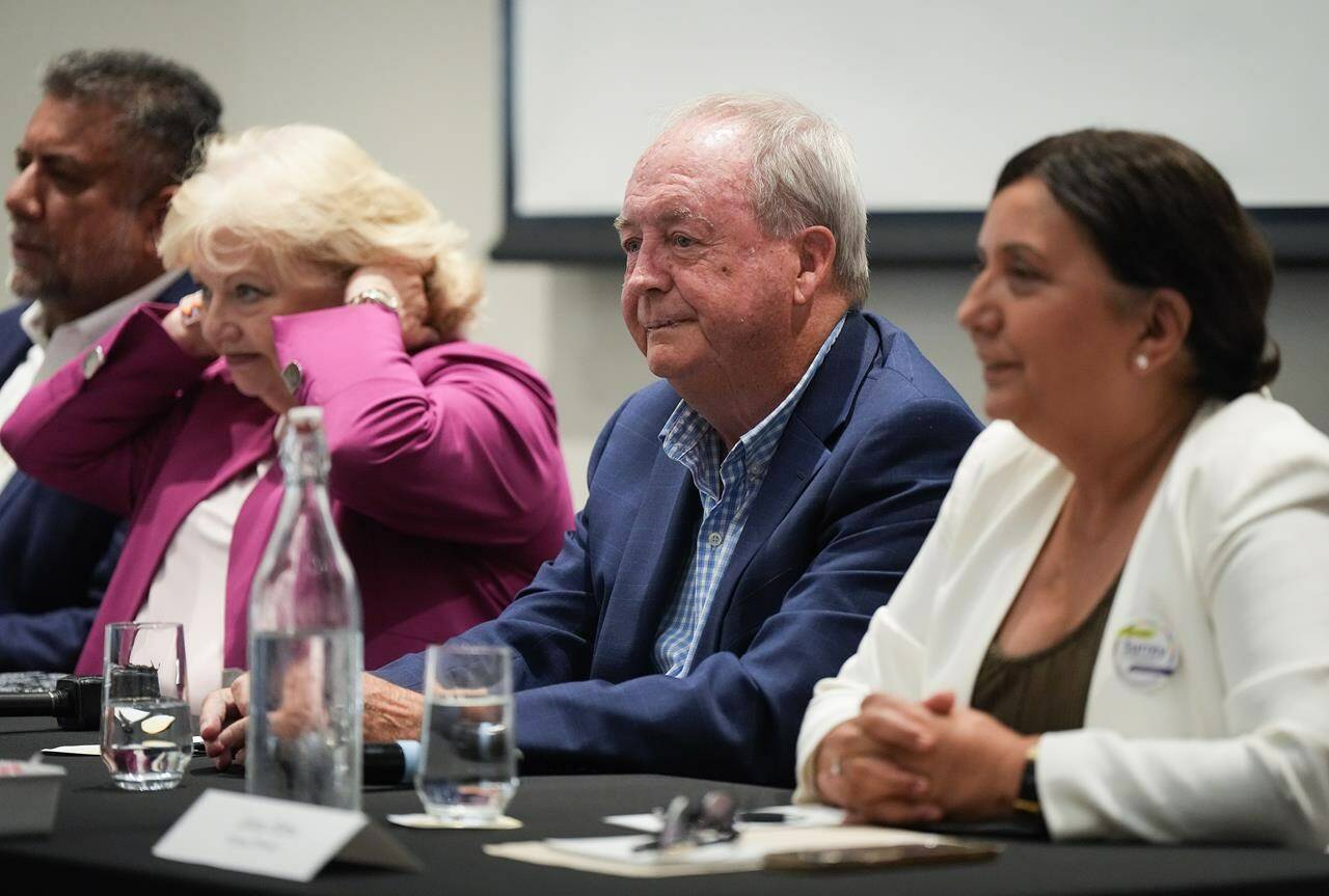 Surrey mayoral candidates, incumbent Doug McCallum, second right, Sukh Dhaliwal, back left, Brenda Locke, second left, and Jinny Sims, right, wait for the start of a candidates meeting in Surrey, B.C., Monday, Sept. 26, 2022. THE CANADIAN PRESS/Darryl Dyck