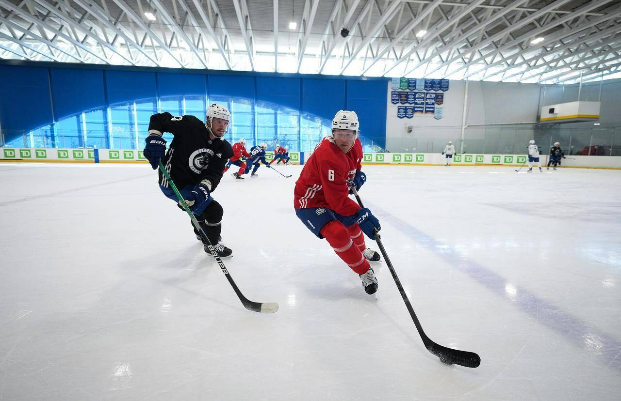 Vancouver Canucks’ Brock Boeser, right, tries to keep the puck away from Oliver Ekman-Larsson, of Sweden, during the NHL hockey team’s training camp in Whistler, B.C., Thursday, Sept. 22, 2022. THE CANADIAN PRESS/Darryl Dyck