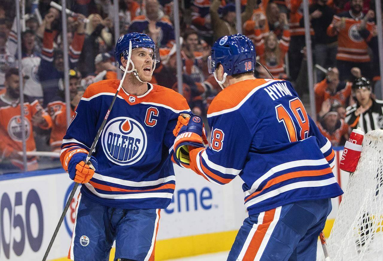Edmonton Oilers’ Connor McDavid (97) and Zach Hyman (18) celebrate a goal against the Vancouver Canucks during second period NHL action in Edmonton on Wednesday, October 12, 2022.THE CANADIAN PRESS/Jason Franson
