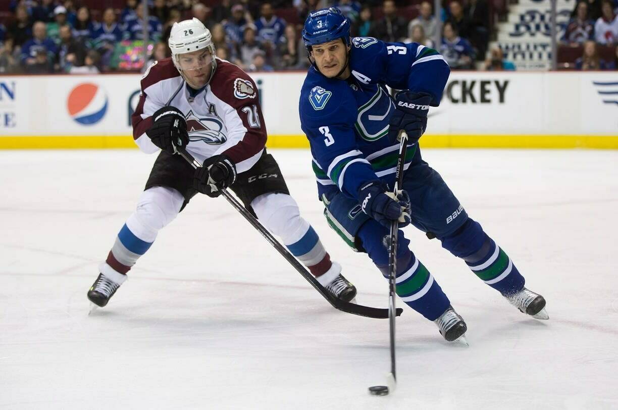 Vancouver Canucks’ Kevin Bieksa, right, skates with the puck as Colorado Avalanche’s Paul Stastny gives chase during first period NHL hockey action in Vancouver, B.C., on Thursday April 10, 2014. Defenceman Kevin Bieksa will sign a one-day contract with the Vancouver Canucks to mark his retirement from the NHL on Nov. 3, the team announced on Thursday. THE CANADIAN PRESS/Darryl Dyck