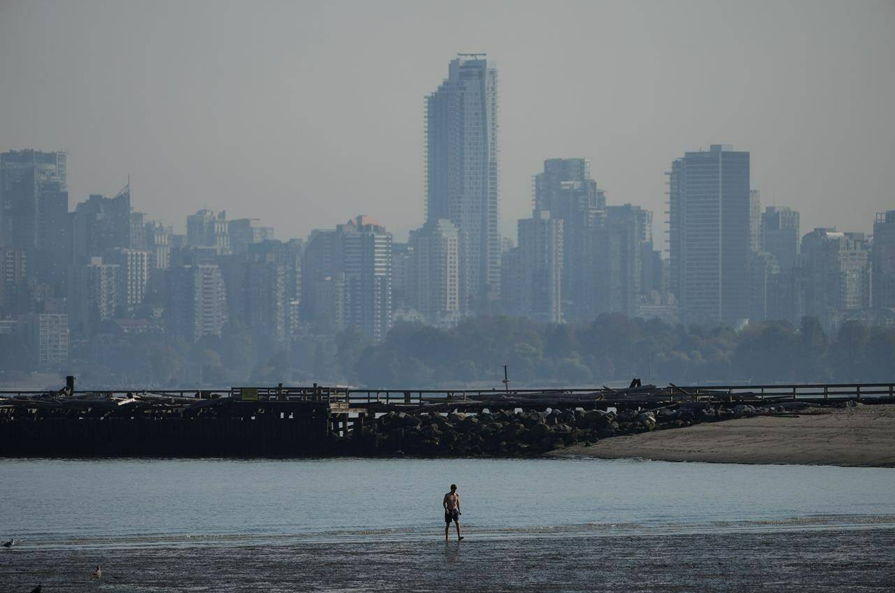 A man walks in the water off Locarno Beach during a stretch of unseasonably warm weather, in Vancouver, B.C., Thursday, Oct. 6, 2022. Water use in Metro Vancouver is much higher, while reservoir levels are lower than normal, prompting the regional district to ask millions of residents and businesses to conserve.THE CANADIAN PRESS/Darryl Dyck