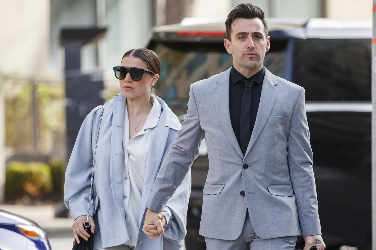 Canadian musician Jacob Hoggard arrives alongside his wife Rebekah Asselstine, for his sex assault trial at the Toronto courthouse, in Toronto, Tuesday, May 10, 2022. A sentencing hearing continues today for Canadian musician Jacob Hoggard, who was found guilty earlier this year of a sexual assault on an Ottawa woman. THE CANADIAN PRESS/Cole Burston