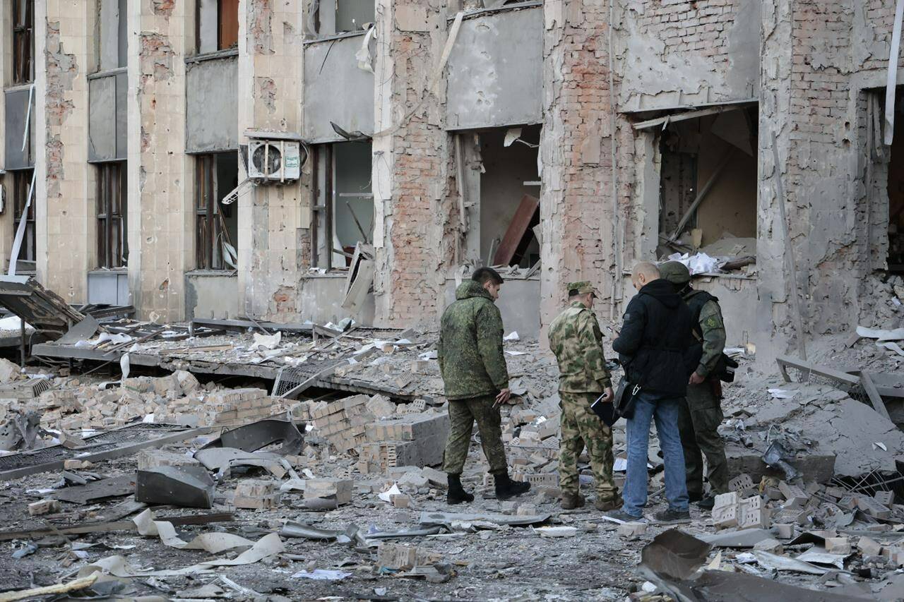 Investigators inspect a site after shelling near an administrative building, in Donetsk, the capital of Donetsk People’s Republic, eastern Ukraine, Sunday, Oct. 16, 2022. According to the Donetsk People’s Republic’s (DPR) mission to the Joint Center for Control and Coordination, six 155mm munitions were fired at Donetsk in the early hours of Sunday. (AP Photo/Alexei Alexandrov)