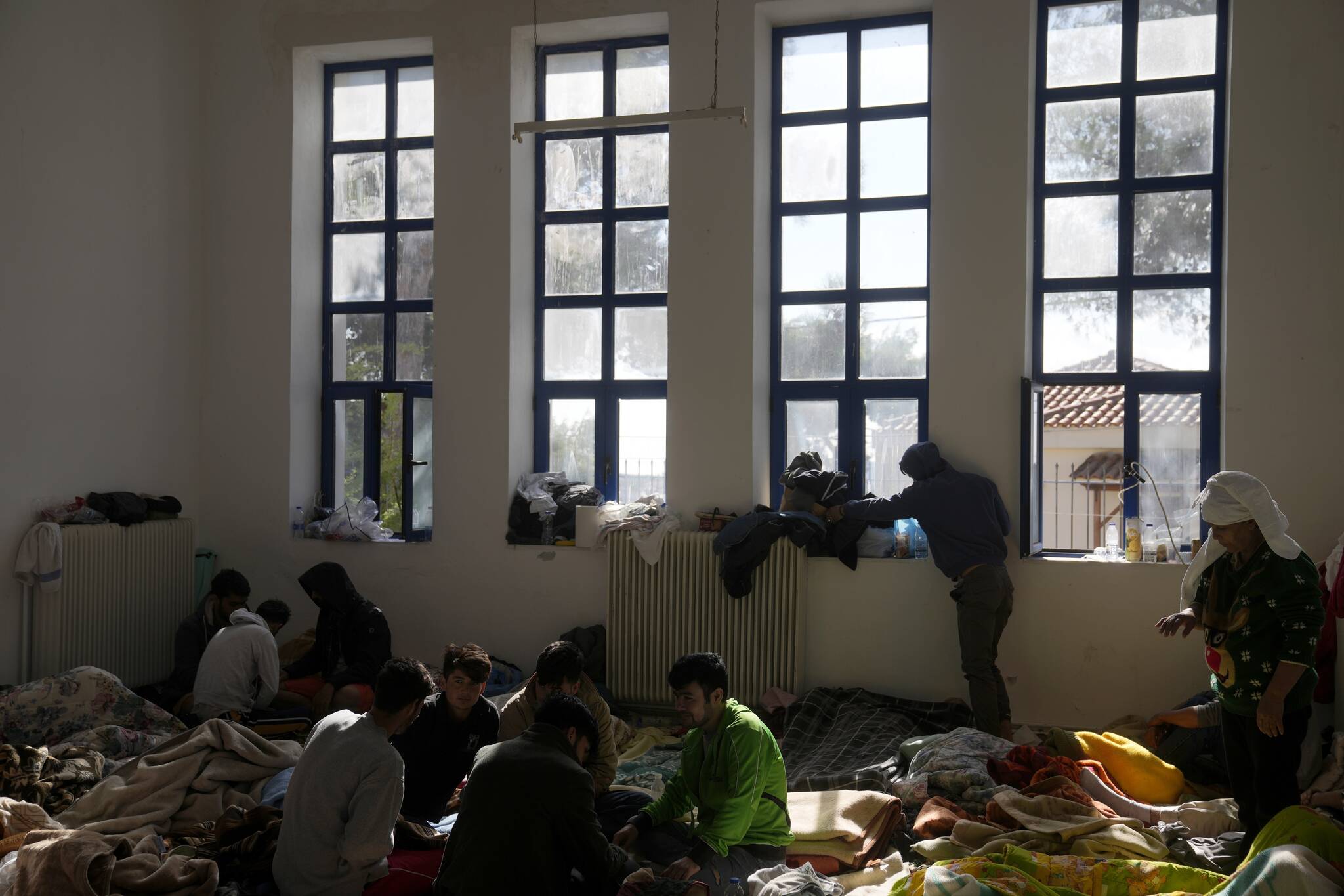 Migrants, most of them from Afghanistan, rest at an old school used as a temporary shelter on the island of Kythira, southern Greece, Friday, Oct. 7, 2022. (AP Photo/Thanassis Stavrakis)