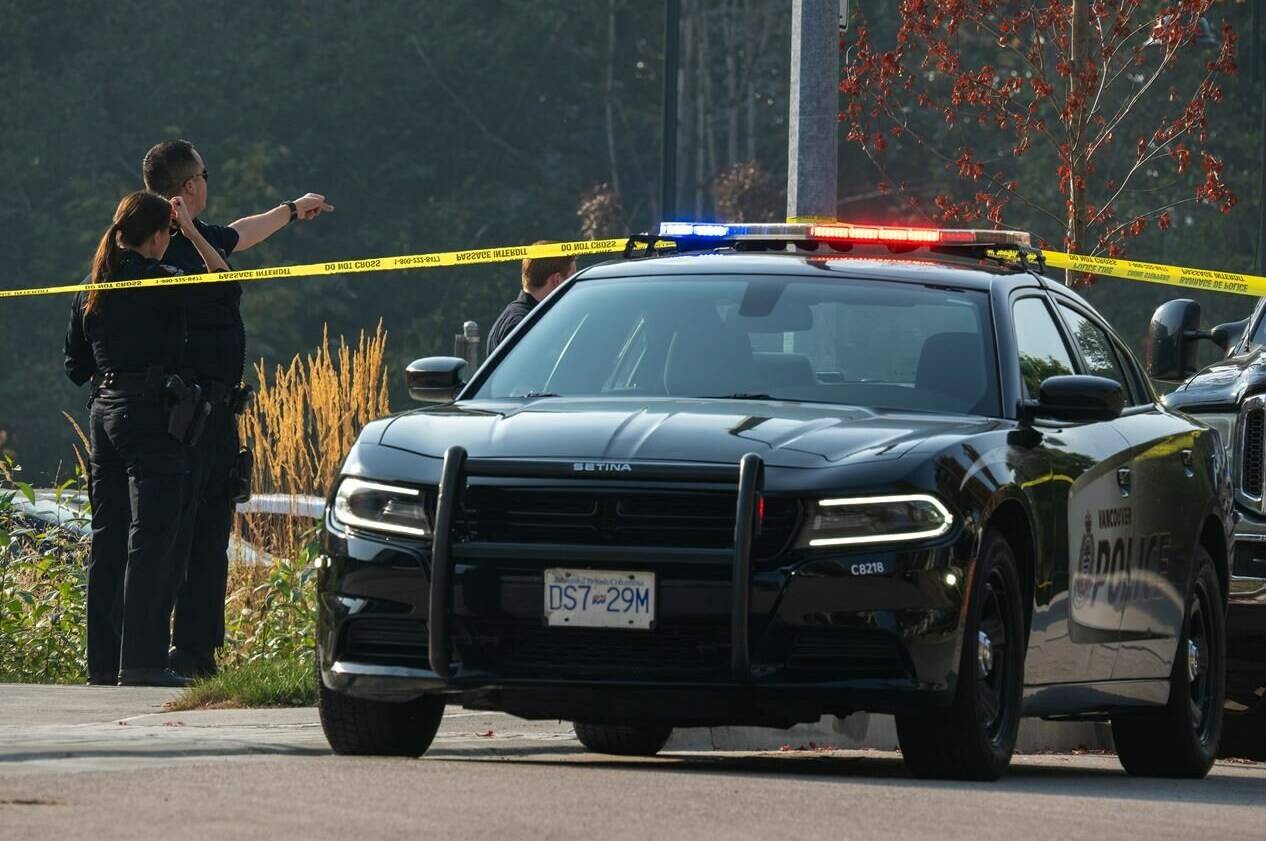 Vancouver police officers are seen near a homeless man’s tent where a female member of the RCMP was stabbed to death in Burnaby, B.C. Tuesday, Oct. 18, 2022. Police have become de facto social workers for people who lack support services while struggling with homelessness, mental illness and substance use, a spokesman for the Vancouver Police Department says. THE CANADIAN PRESS/Jonathan Hayward