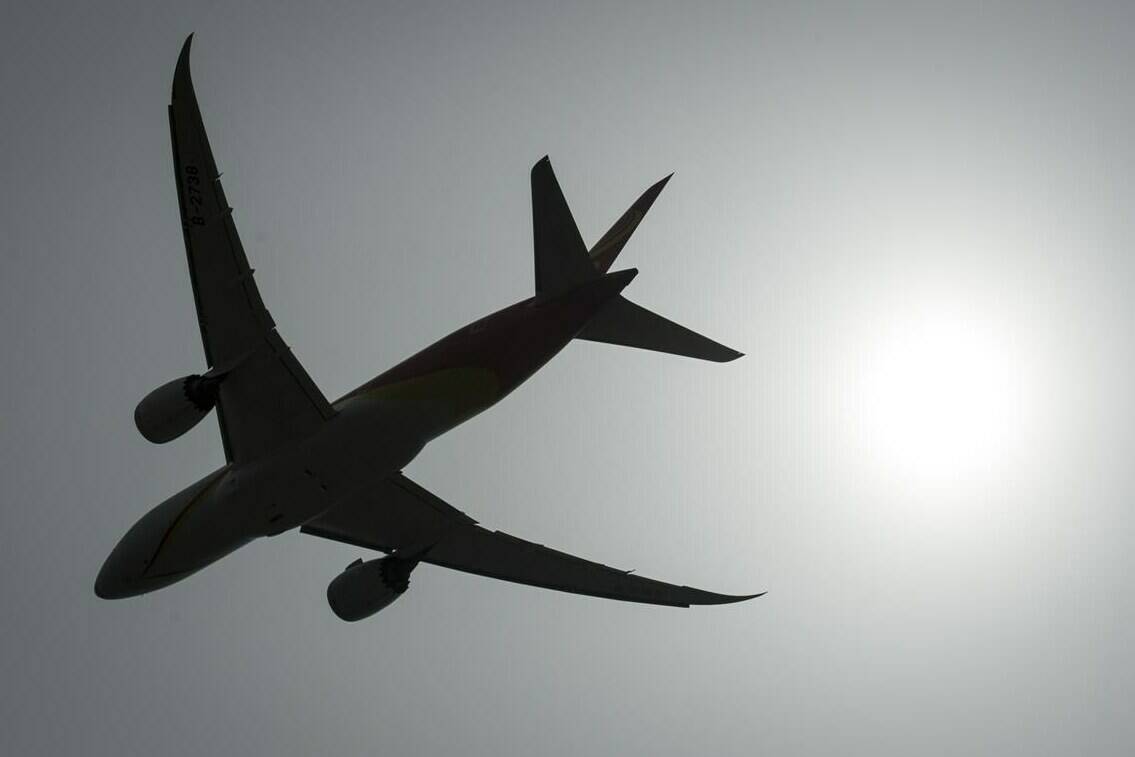 A plane is silhouetted as it takes off from Vancouver International Airport in Richmond, B.C., Monday, May 13, 2019. As inflation remains hot around the world, Canadians trying to escape the cold this winter will be looking to save during the peak travel season. THE CANADIAN PRESS/Jonathan Hayward