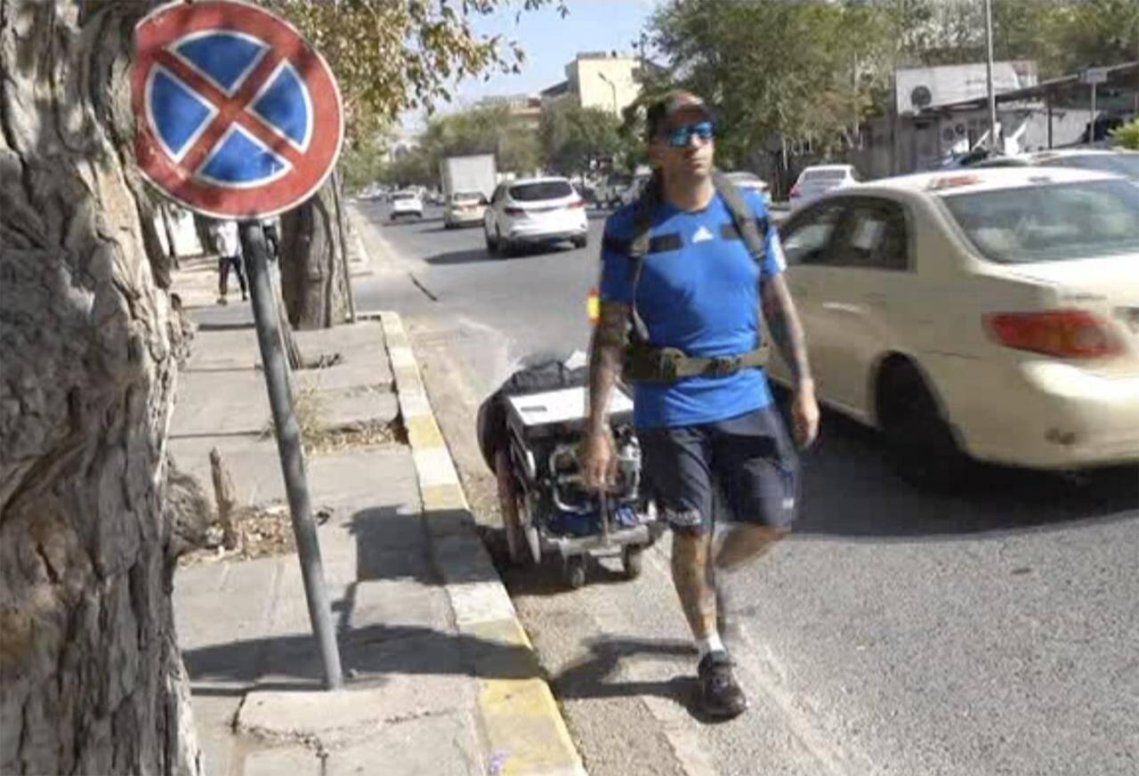 In this frame grab from video, 41-year-old Santiago Sánchez, a Spanish man who was documenting his travel by foot from Madrid to Doha for the 2022 FIFA World Cup carries a suitcase in a wheeled cart, in Sulaymaniyah, Iraq, Sept. 28, 2022. Sánchez has not been heard from since crossing into Iran three weeks ago, stirring fears about his fate in a country convulsed by mass unrest. That’s according to his family, who spoke to The Associated Press on Monday, Oct. 24, 2022. He was an experienced trekker, former paratrooper and fervent soccer fan. (AP Photo)