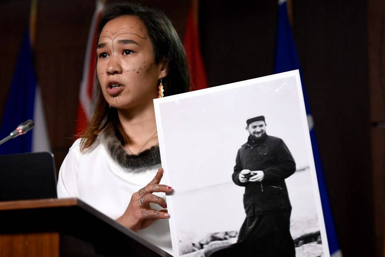 NDP MP Mumilaaq Qaqqaq holds a photo of Johannes Rivoire, a priest who is wanted in Canada but resides in France, during a news conference on Parliament Hill in Ottawa, on Thursday, July 8, 2021.The federal government says France has denied an extradition request for the priest.THE CANADIAN PRESS/Justin Tang