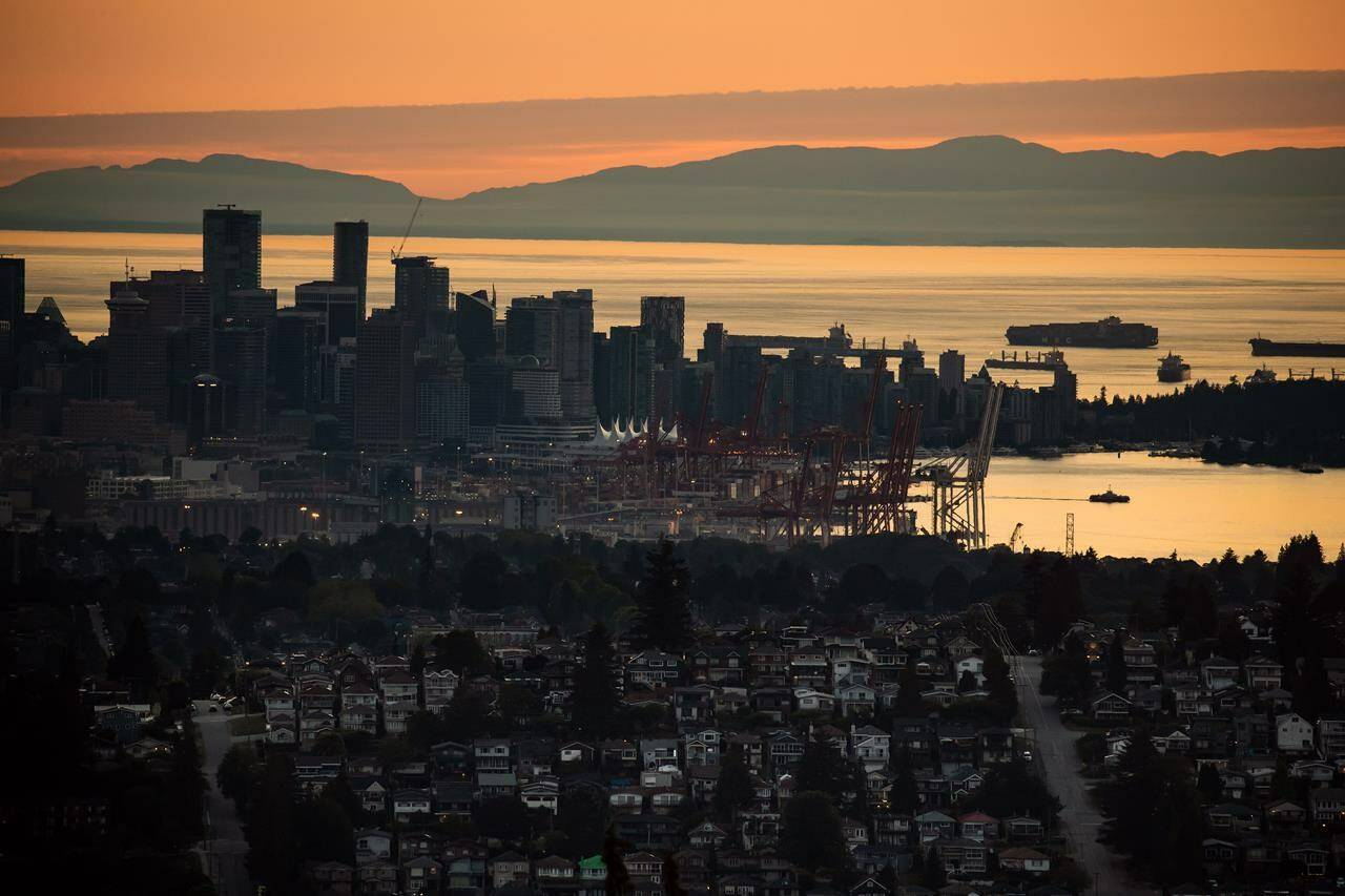 A Seabus passenger ferry, right, travels across Burrard Inlet at sunset as downtown Vancouver and the port are seen from Burnaby Mountain, on Monday, July 11, 2022. Chief Jen Thomas of the Tsleil-Waututh Nation says an Indigenous-led bid to host the 2030 Olympics in British Columbia is over after the province declined its support. THE CANADIAN PRESS/Darryl Dyck