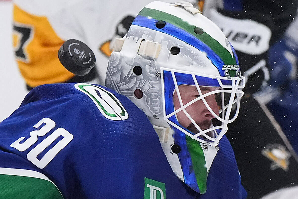 The puck deflects over Vancouver Canucks goalie Spencer Martin’s shoulder and stays out of the goal during the second period of an NHL hockey game against the Pittsburgh Penguins in Vancouver, on Friday, October 28, 2022. THE CANADIAN PRESS/Darryl Dyck
