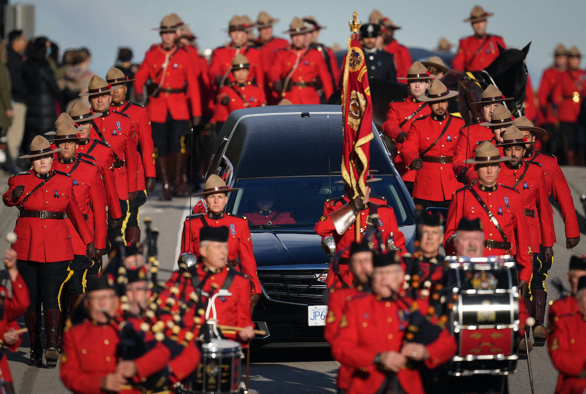 RCMP officers in red serge march alongside a hearse carrying RCMP Const. Shaelyn Yang’s casket to her regimental funeral, in Richmond, B.C., on Wednesday, November 2, 2022. The 31-year-old officer was stabbed to death two weeks ago while she helped a City of Burnaby employee issue an eviction notice to a man living in a tent at a local park. THE CANADIAN PRESS/Darryl Dyck