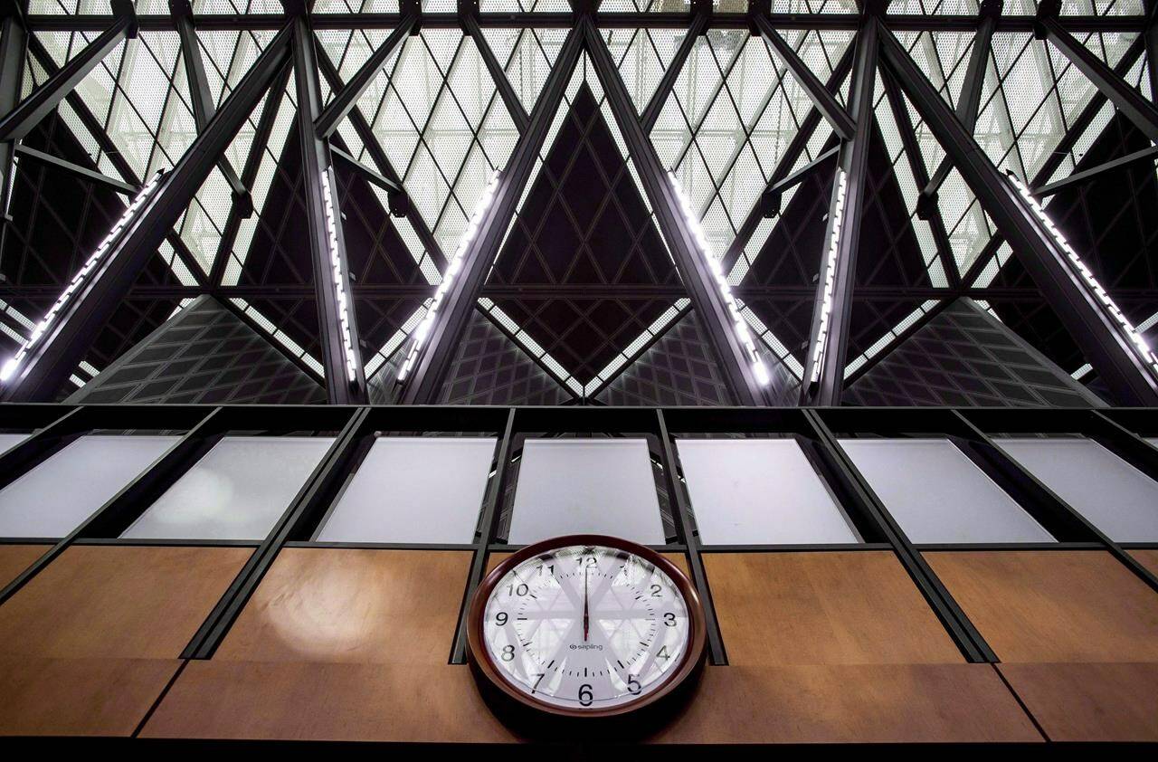 The structure holding up the glass roof is reflected in a clock on the wall of the interim House of Commons Chamber West Block on Parliament Hill in Ottawa on Friday, June 15, 2018. THE CANADIAN PRESS/Justin Tang